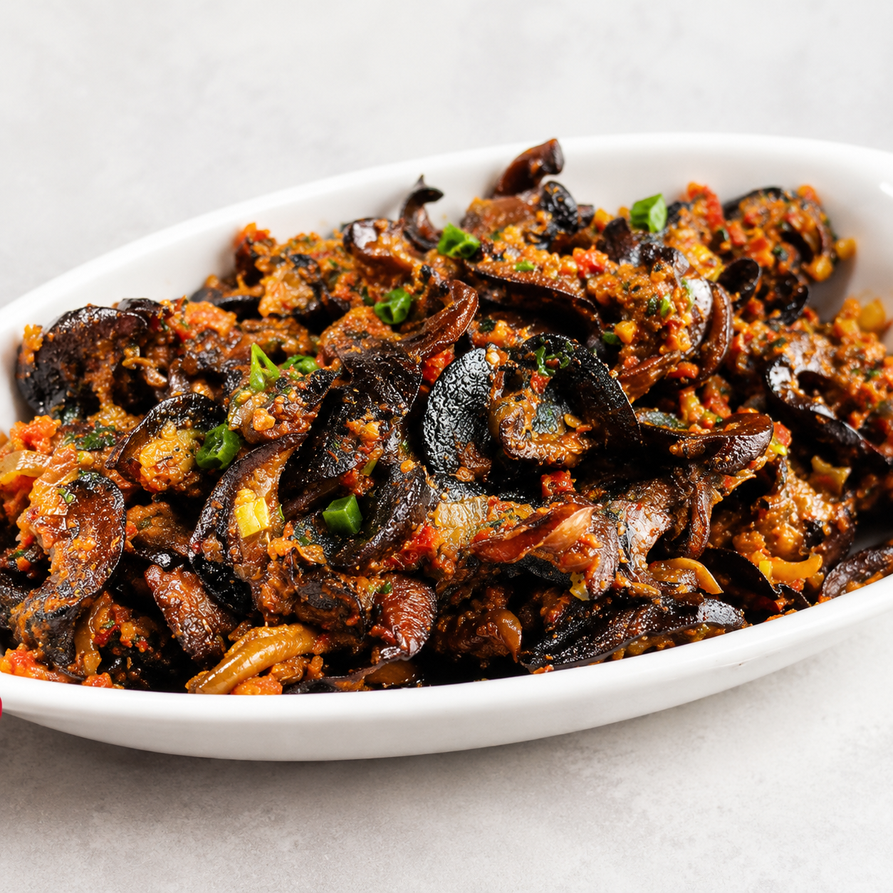 Peppered snails — Snails tossed in a fiery, glossy pepper sauce